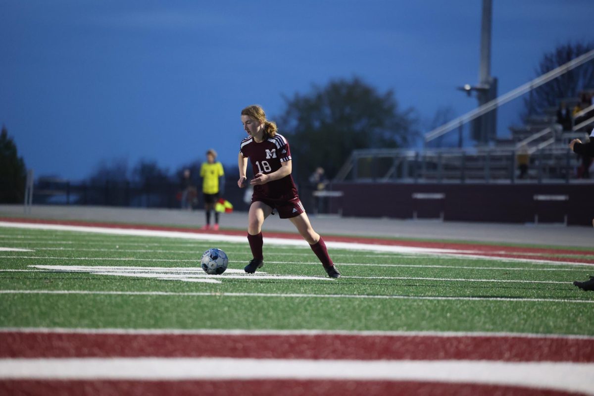 Sophomore Rose Pisarik (18) carries the ball up the field with no opponents around to sop her April 17. 
