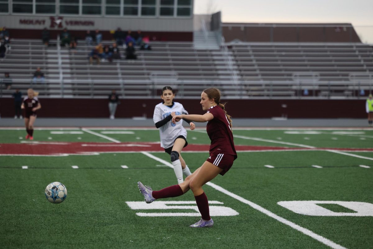 Junior Lilly Cook (5) steps out of the defensive line to kick the ball to the other side of the field April 17. 