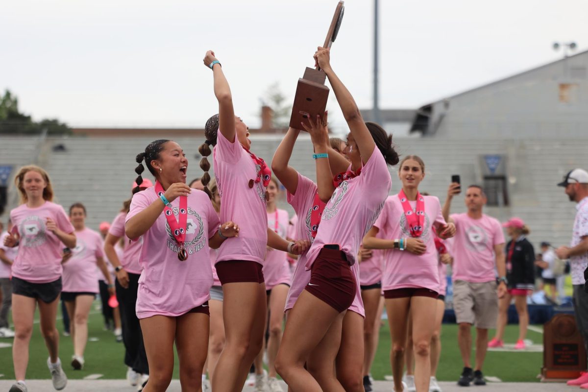 The girls track team celebrates the Class 3A State Runner-up trophy May 24.