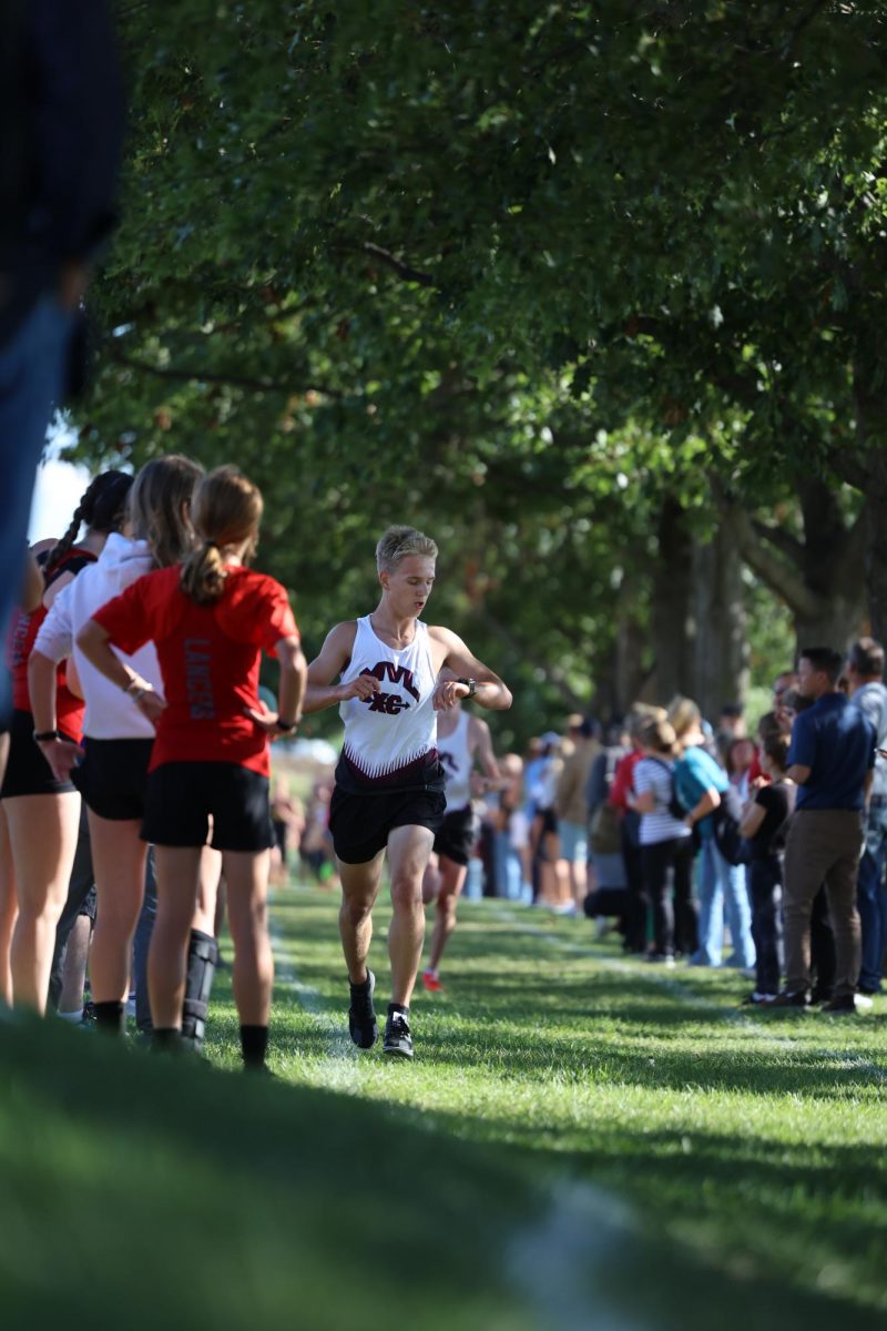 Junior Chasen Caskey checks his pace through his race on Aug. 26th at the home meet.
