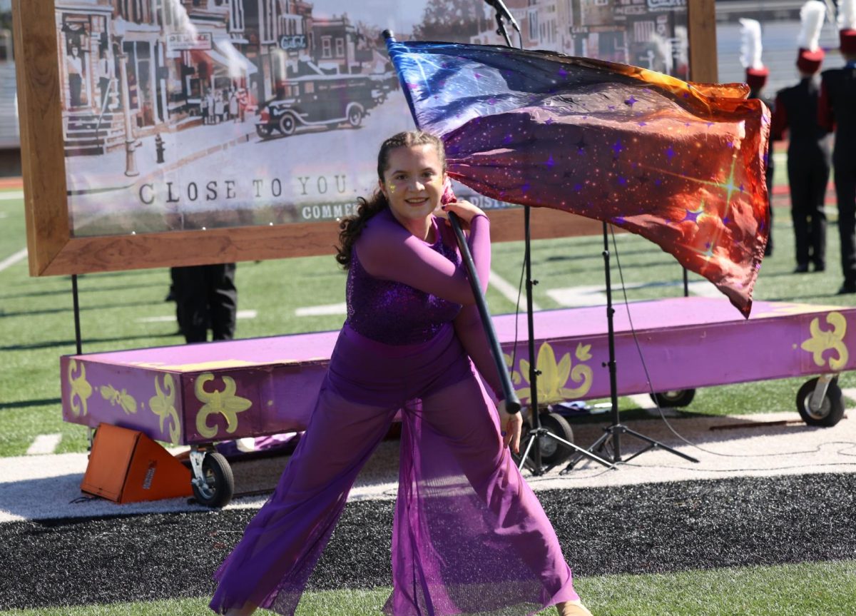 Senior Emily Giel finishes her color guard solo during the Marching Mustangs' performance on Sept. 27.