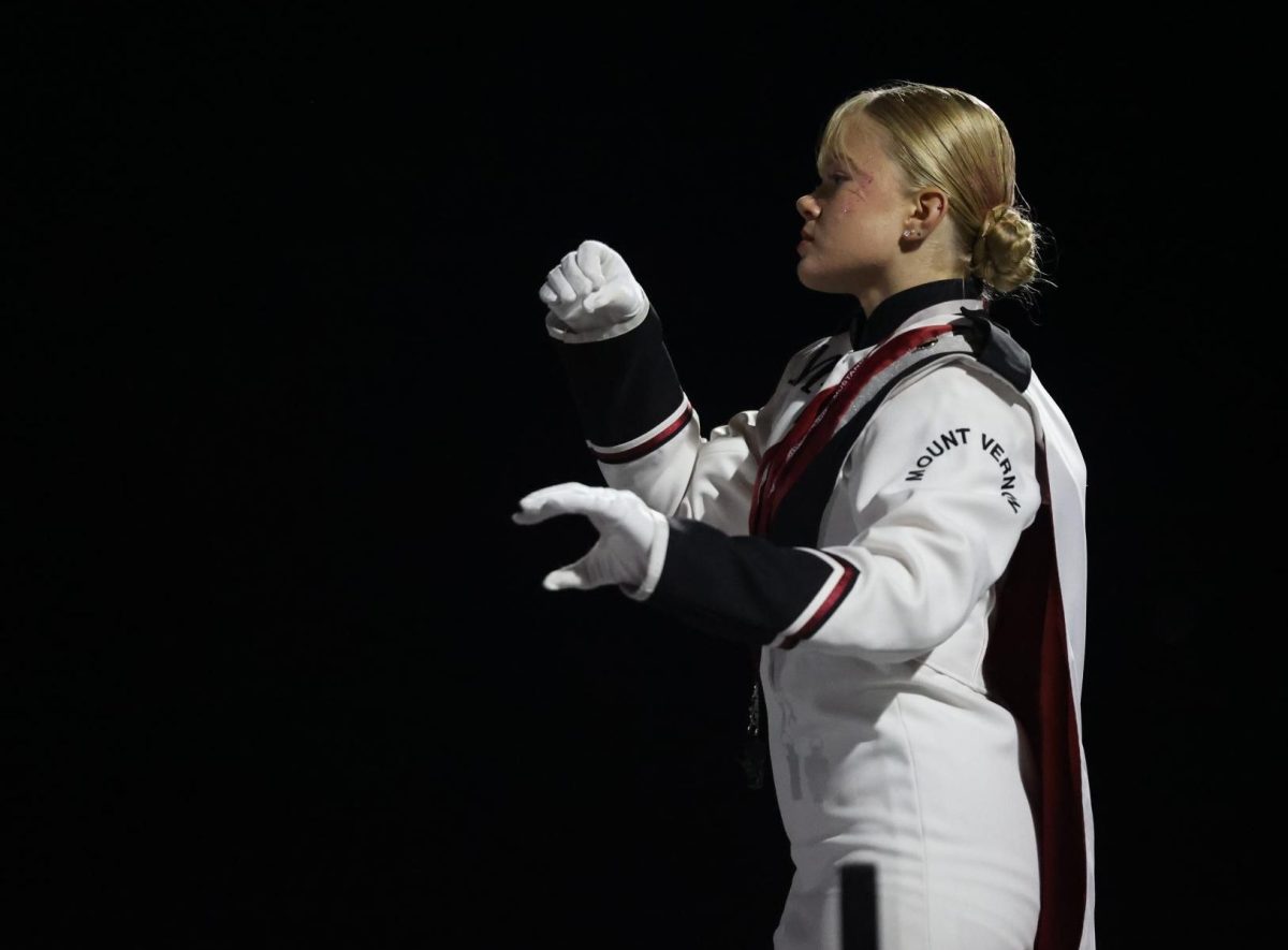 Senior Drum Major Korah Jo Robinson conducts the marching band during their halftime show on Sept. 5. 