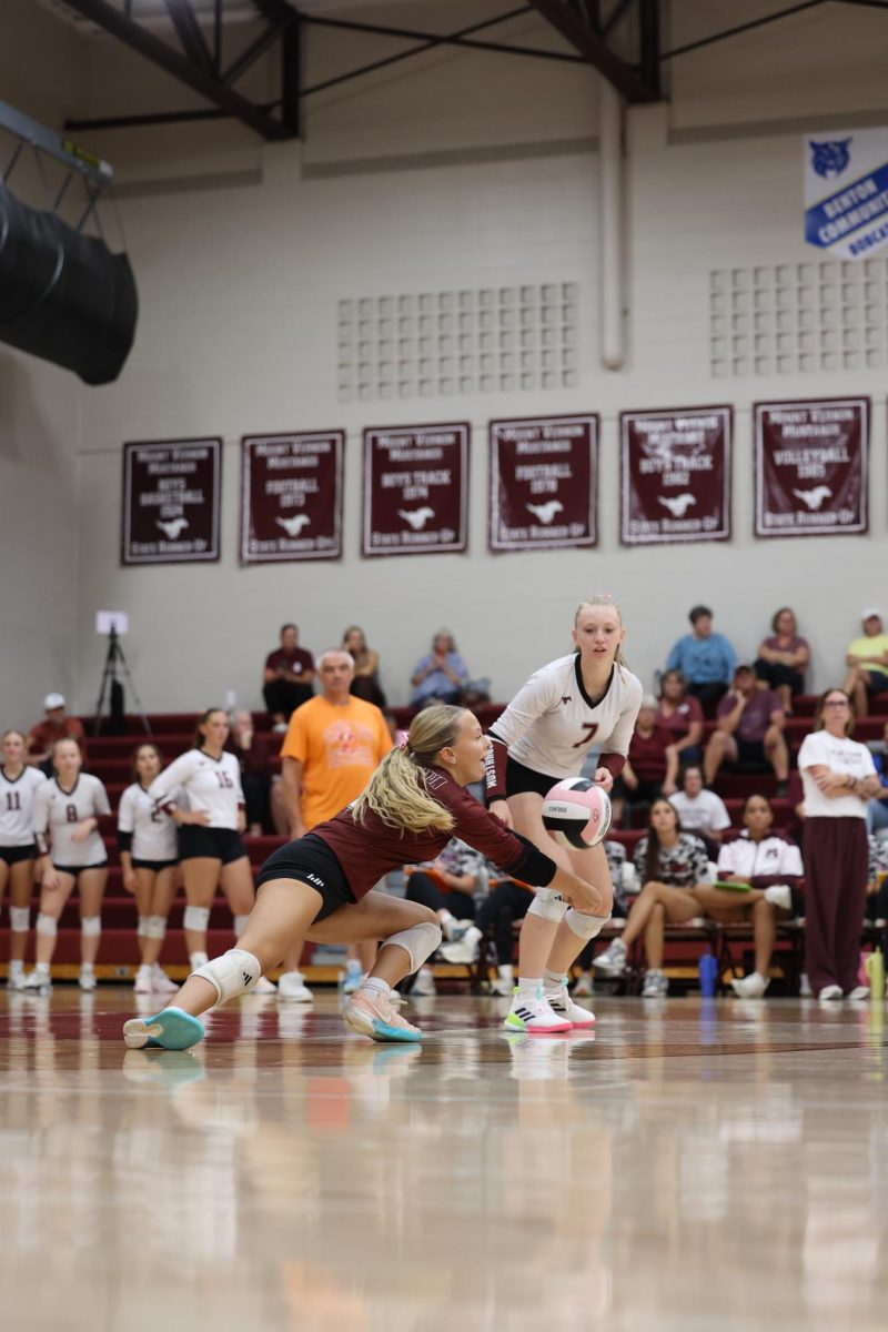 Junior #1 Mavrik Schweer digs a ball from a West Delaware player. 