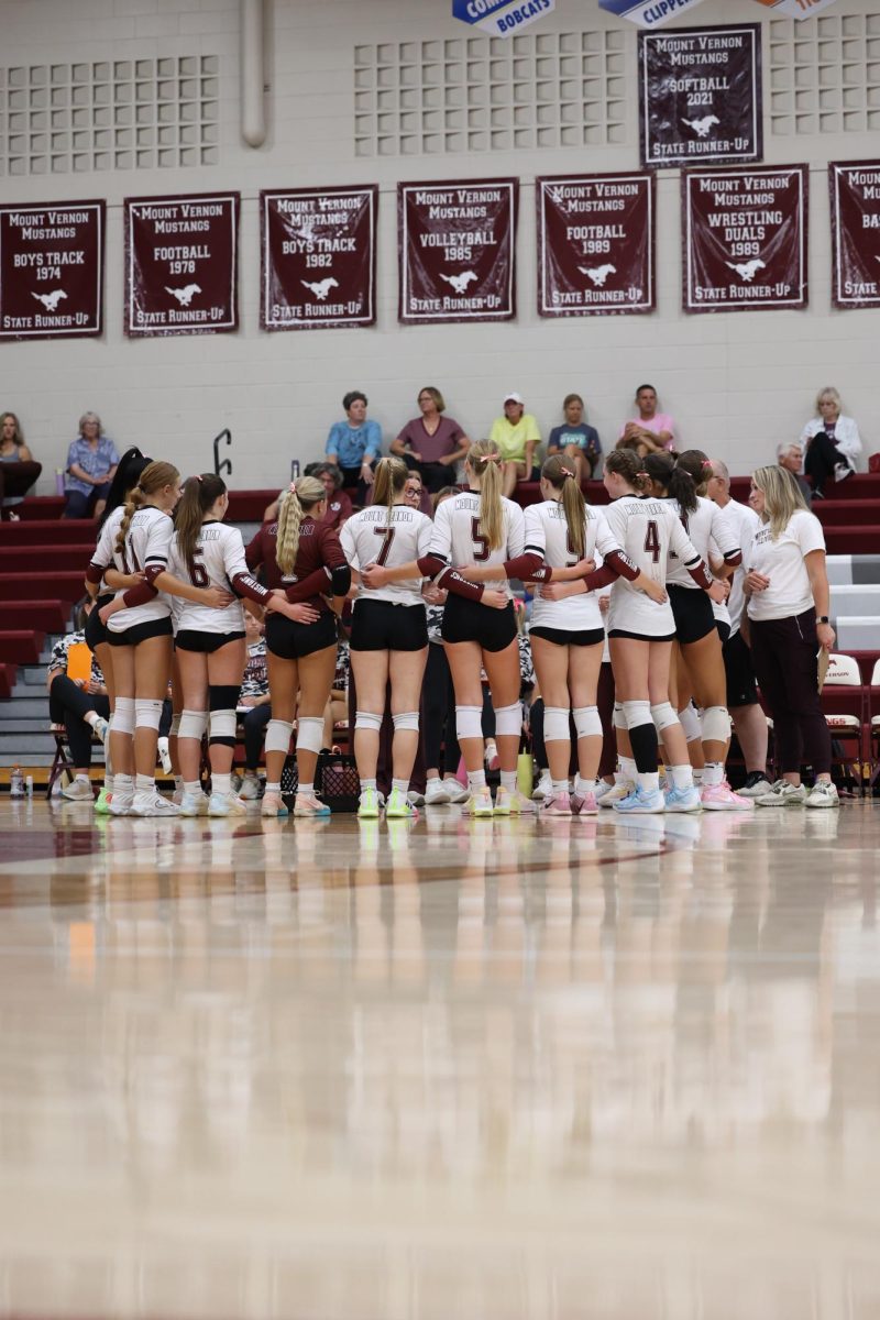 The Mount Vernon volleyball team huddles around during a timeout.