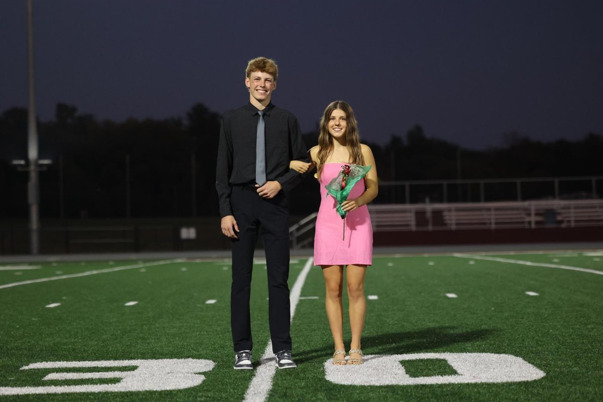 Seniors Kiersten Swart and Landon Wilson smile before the crowing of homecoming king and queen on the night of October 2. 
