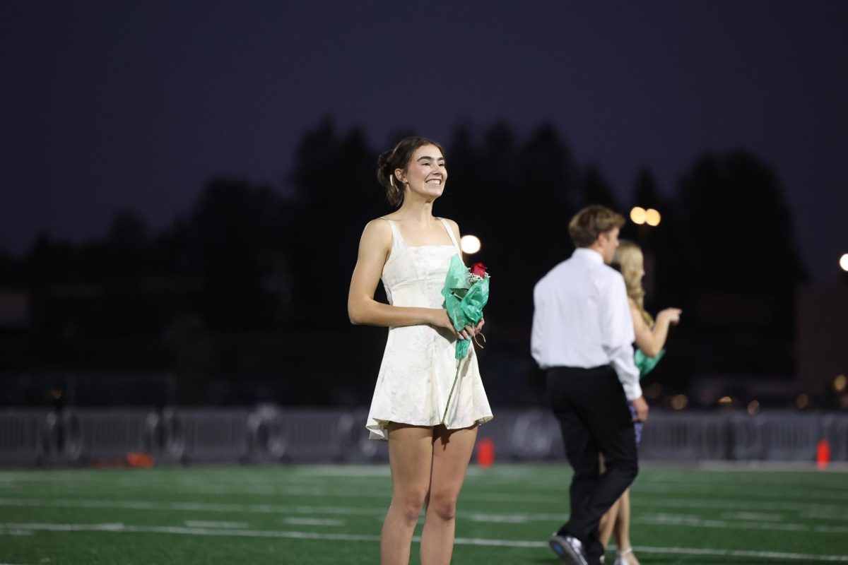 Senior Grace Hale beams at crowd as they scream and cheer for her crowning while she waits for the homecoming king to be revealed on October 2. 