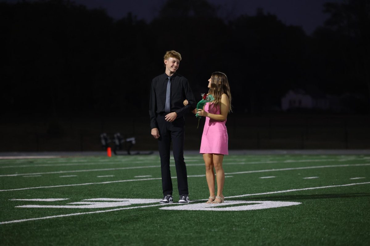 Seniors Landon Wilson and Kiersten Swart share a glance and smile after the announcement of Landon being crowned homecoming king 2025 on October 2. 