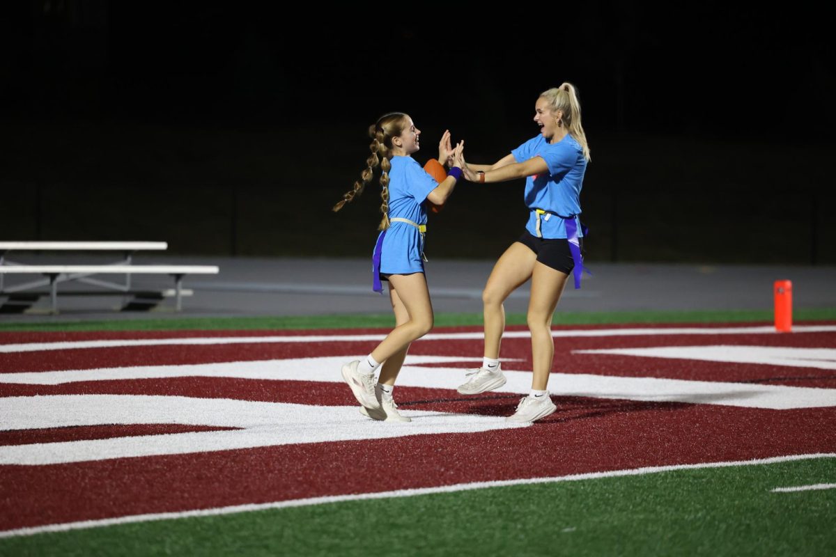 Freshman Lana Riniker scores a point for the surfers and junior Avri Trumblee-Looney celebrates with her Oct. 2. 