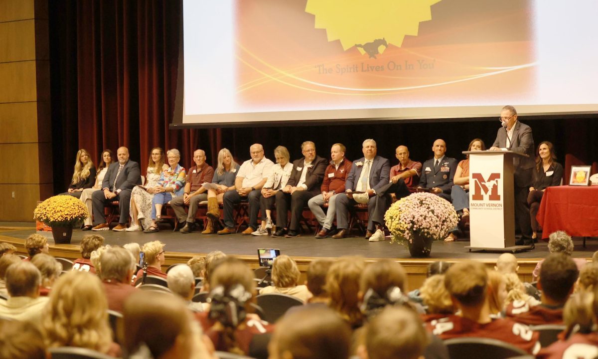 2025 inductees into the Alumni Hall of Fame sit on stage in the PAC with the people who nominated them. John Rife was the emcee of the event