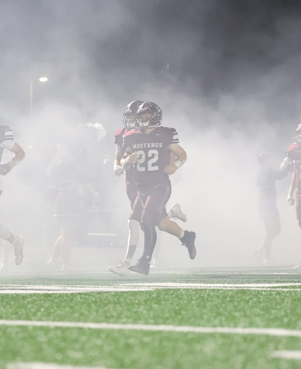 Jakob Yock (22) runs through the smoke before his game on Friday, Oct. 3. 