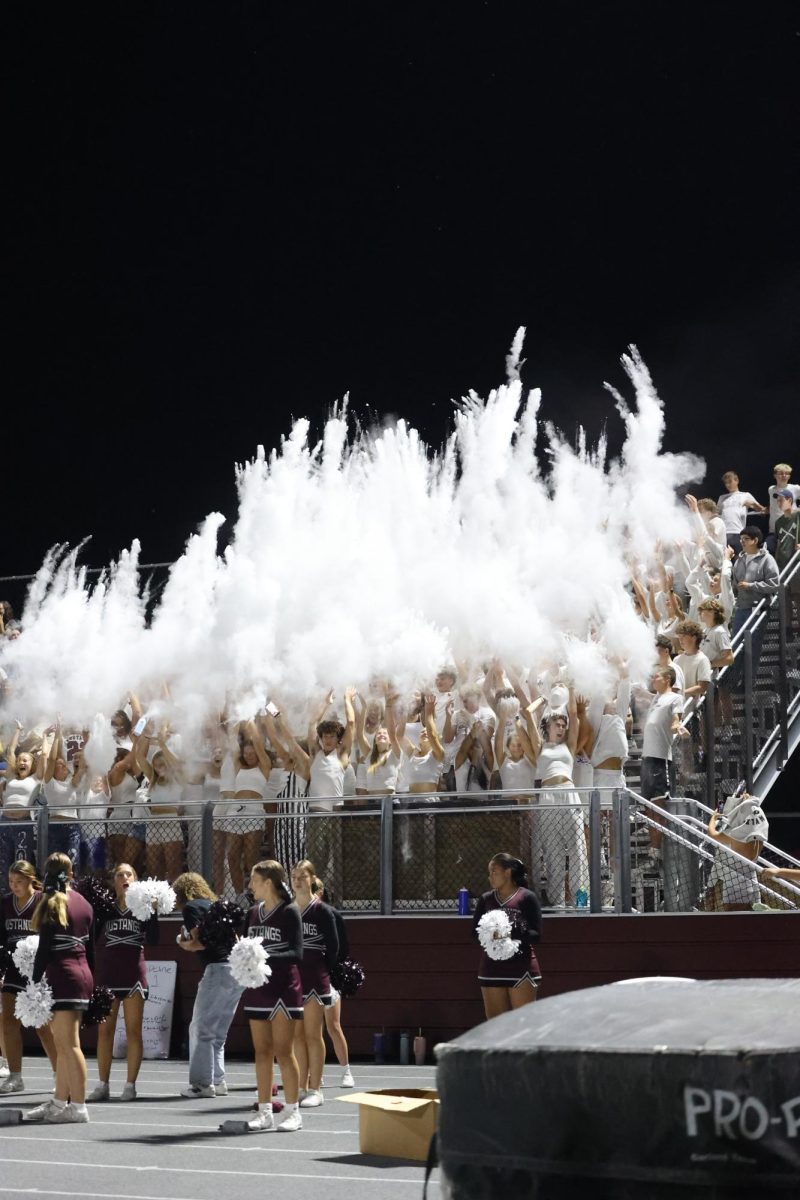 Students of the Mount Vernon High School toss up baby powder in celebration of the homecoming game. 