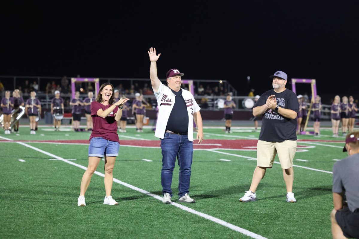 Alumnus Dave Ryan '85 acknowledges the crowd during the Alumni recognition at the halftime homecoming. Ryan was inducted for the Community Impact award. 