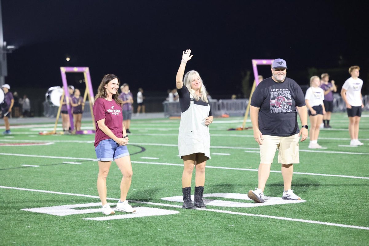 Alumna Nikki Nelson Pauli '98 waves during the Alumni recognition at the homecoming football halftime. Nelson Pauli was inducted for the Athletic award.