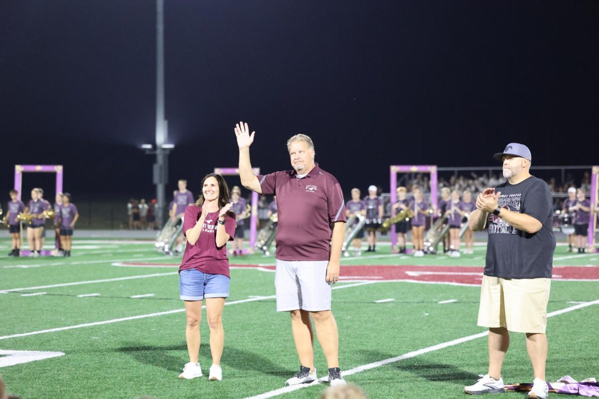 Alumnus Dennis Jordan '87 waves as he is recognized during the homecoming halftime. Jordan was inducted for the Service award.
