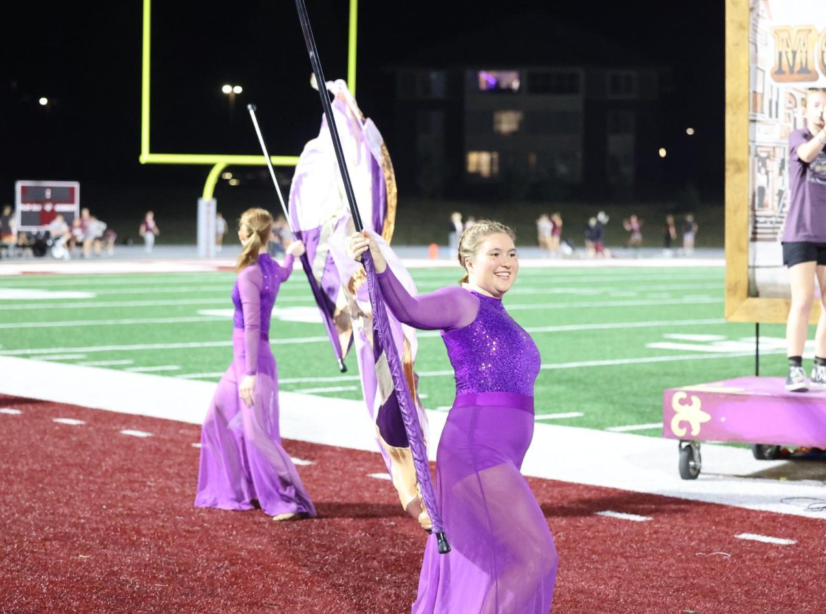 Seniors Mae Krapfl and Ingrid Morf perform their color guard duet together during the homecoming football halftime. 