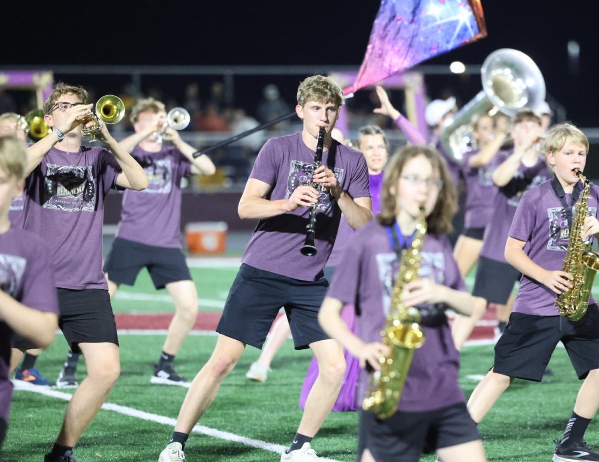 Senior Nathan Conrad leans with the rest of the band as they perform their show "Reminisce" on Oct. 3. 