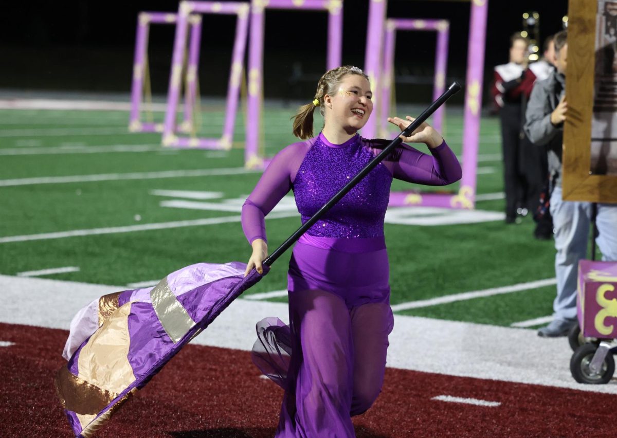 Senior Mae Krapfl completes her color guard performance during the Marching Mustangs’ show.