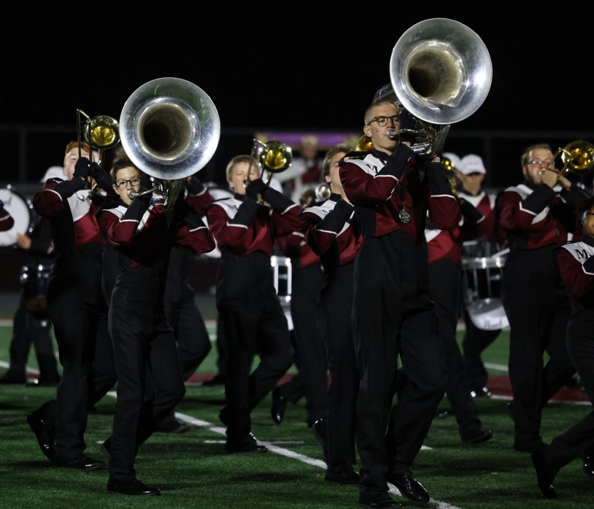 Eighth grader Mitchell Covington and senior Michael Covington march with the band during the outdoor finale on Oct. 20.