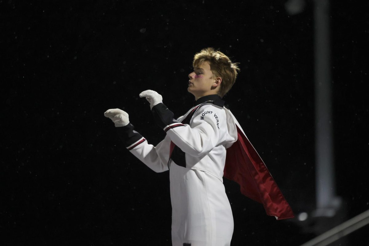 Sophomore drum major Andrew Weber conducts the marching band during their show on Oct. 20.