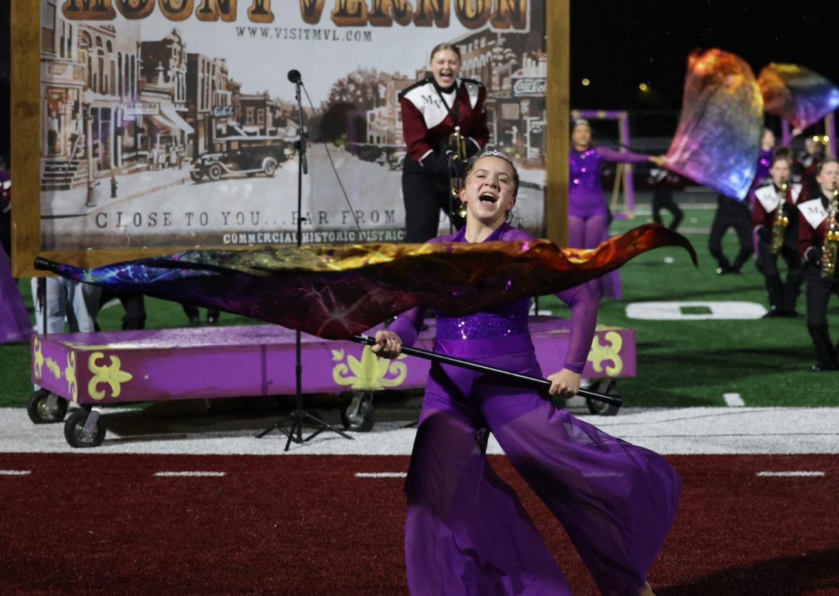 Senior Emily Giel triumphantly completes her final color guard solo during the performance on Oct. 20.
