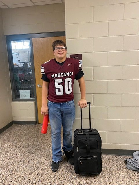 Junior Dylan Marting poses with his suitcase on anything but a backpack day on Oct. 3.