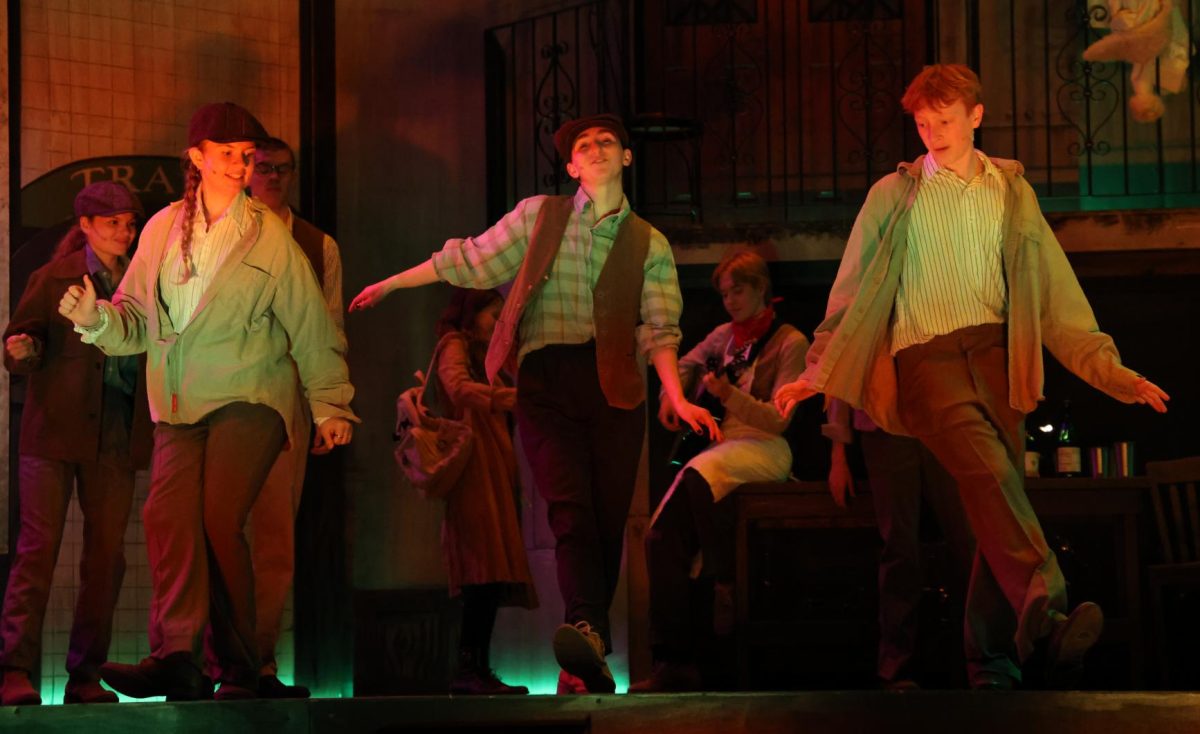 Senior Norah Weber, junior Anna Stephens, and freshman Isaiah Lewis live it up during the Hadestown dress rehearsal on Nov. 3.