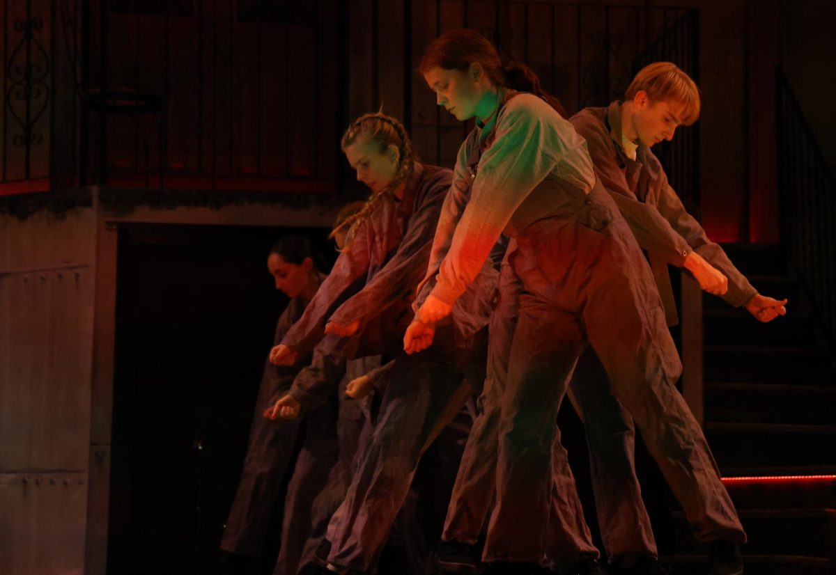 The workers chorus slave away on Hades' wall during "Way Down Hadestown (Reprise)".