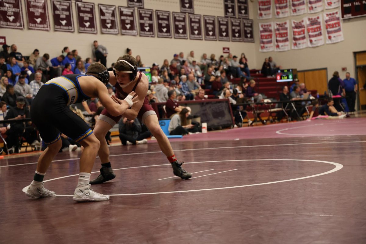 Freshman Camden Meyer wrestles his Benton opponent in the 126 weight class.