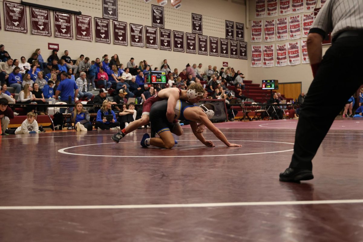 Junior Clayton Martin wrestles Brock Cornigan of Benton High School.