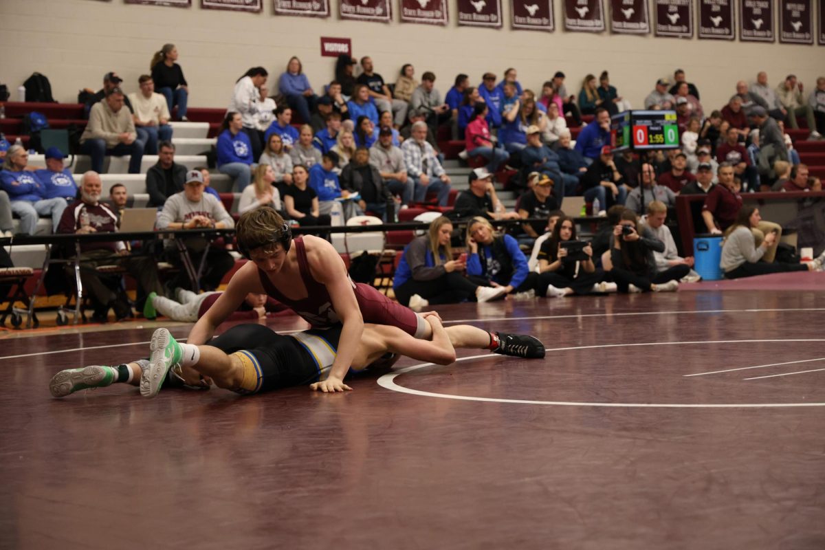 Freshman Avery Paustian wrestling a student of Benton High School.