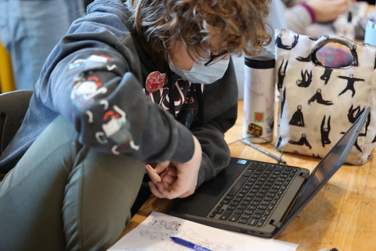 Sophomore Sunny Rian takes a step back from sketching to check instructions from Bonnie Aherns on her computer while also listening to music.