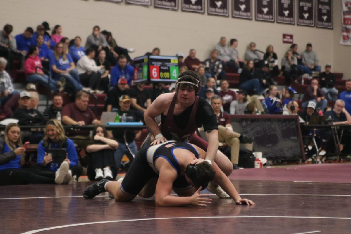 Junior Andrew Dix (215) wrestles during the wrestling triangular.