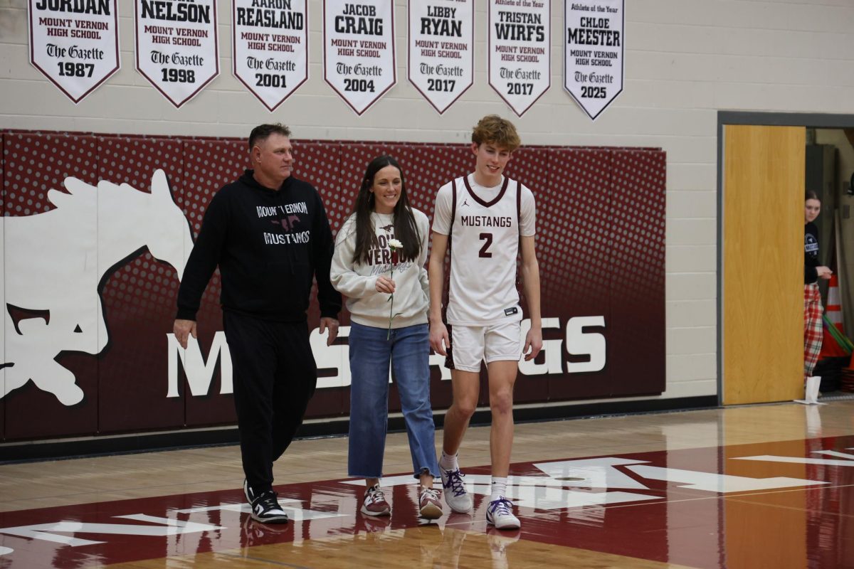 Landon Wilson walks with his parents as he is honored on Senior Night, Feb. 10. The boys won their game against CCA 65-47.