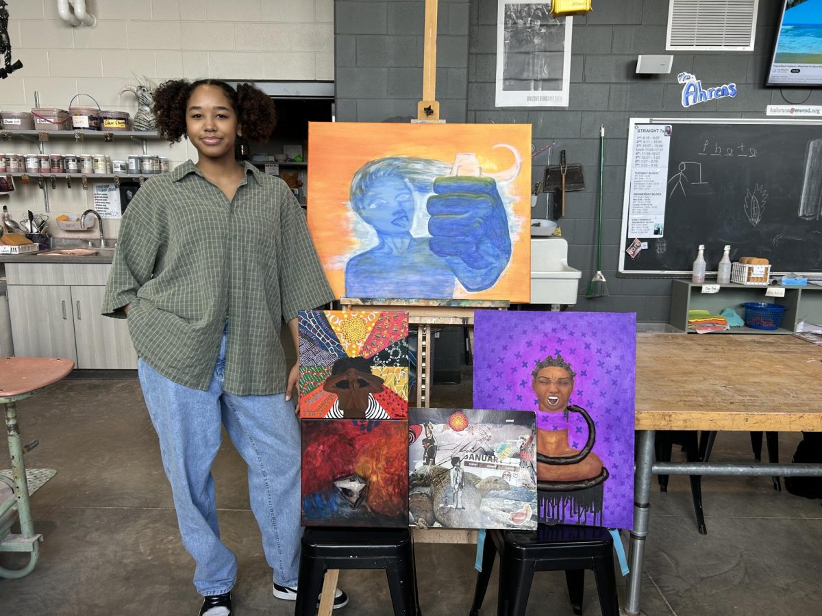 Rose Daoud stands with a selection of her paintings.