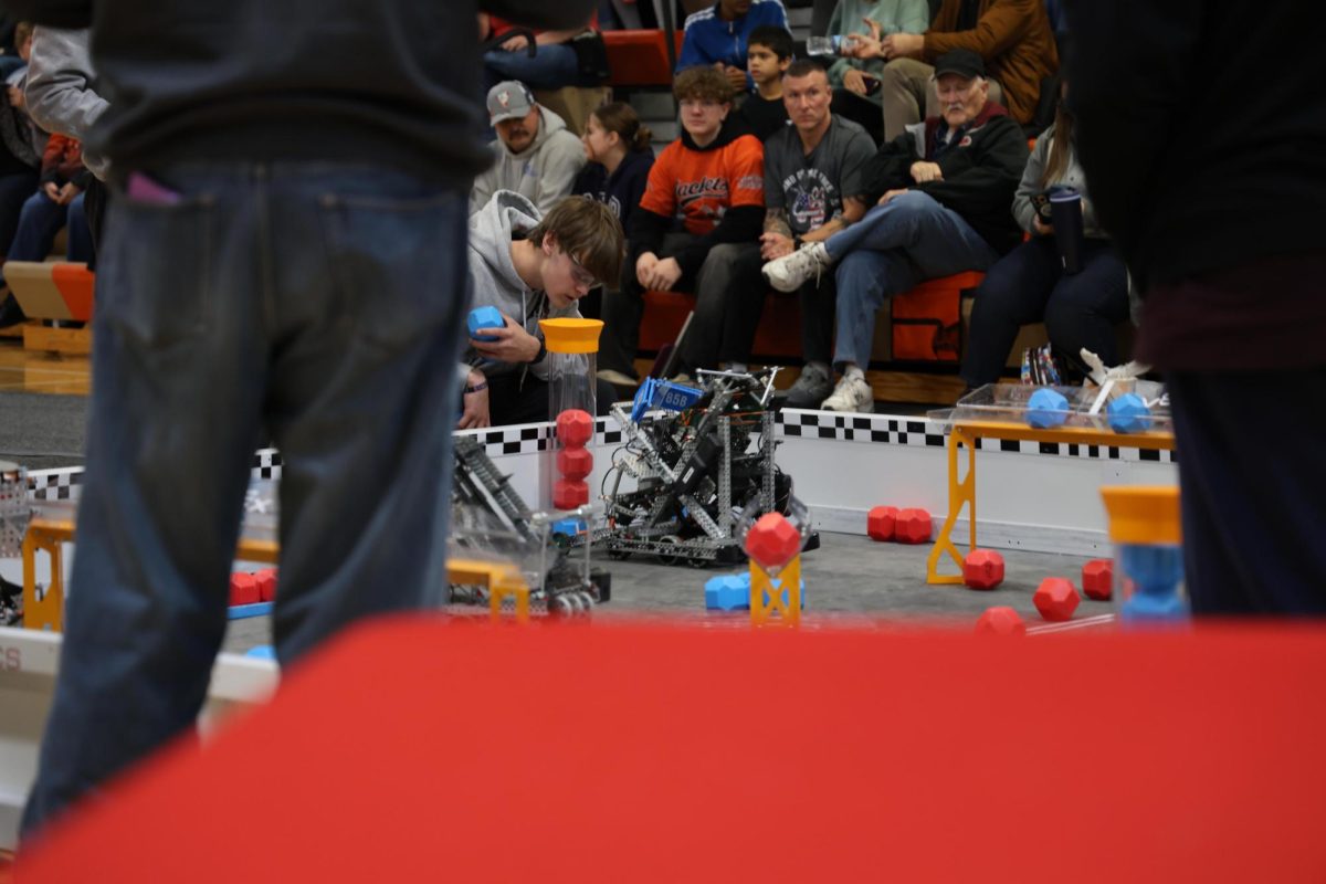 Matthew Bradbury, kneels down to check on his robot. 