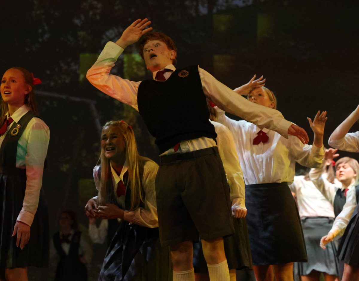 Freshman Isaiah Lewis (Nigel) watches as Amanda is thrown away by Trunchbull. 