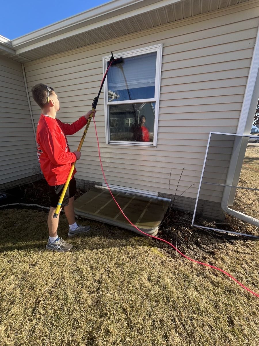 Caleb Keegan cleaning windows for his business