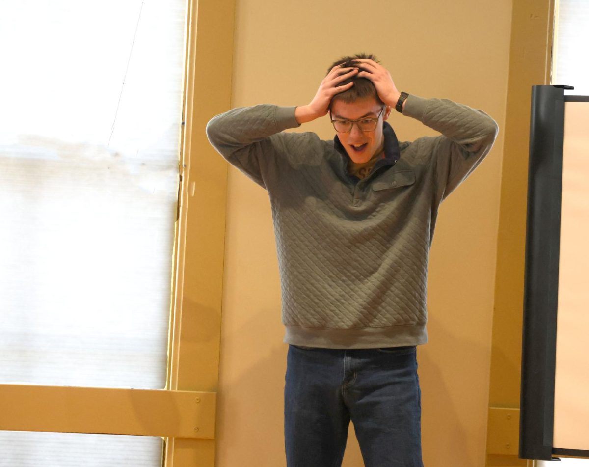 Senior Michael Covington stares in shock after he invents the tricycle during his Improv performance at the All-State showcase on March 29.