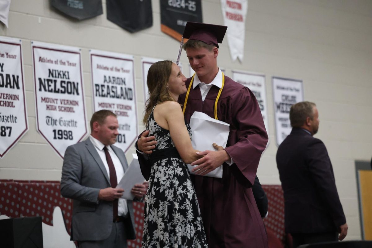 Brogan Meyer accepts his diploma from his mother, school board member Kristi Meyer.