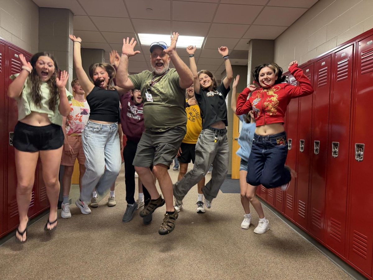 World language teacher Tom Wilkinson jumps in the hallway with his final class at the end of the last day of school May 28.
